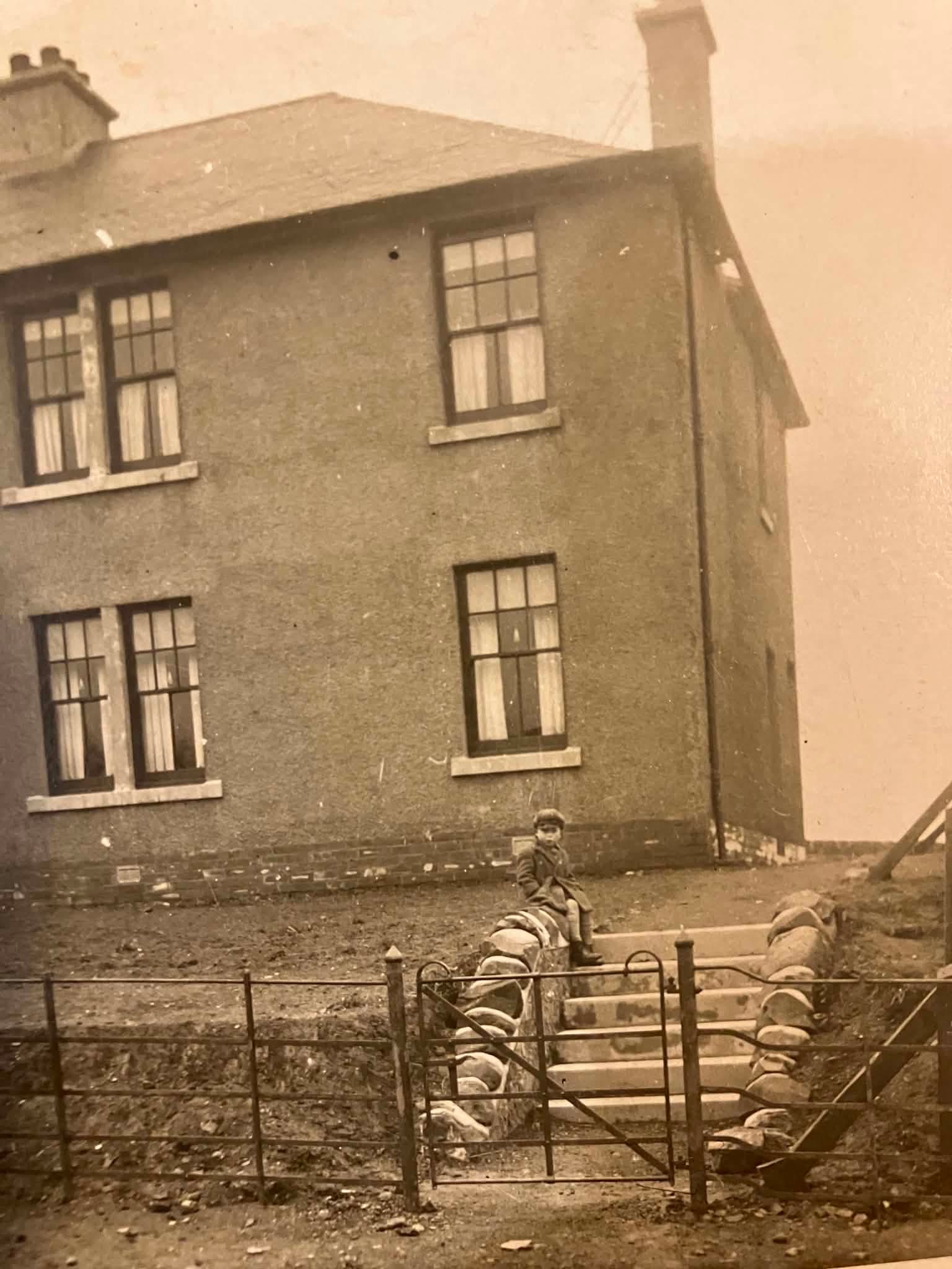 Bill Bowskill, aged six, sitting outside his house in Elderslie, Glasgow, 1929